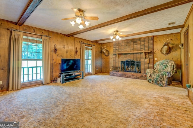 unfurnished living room with ceiling fan, a textured ceiling, and wood walls