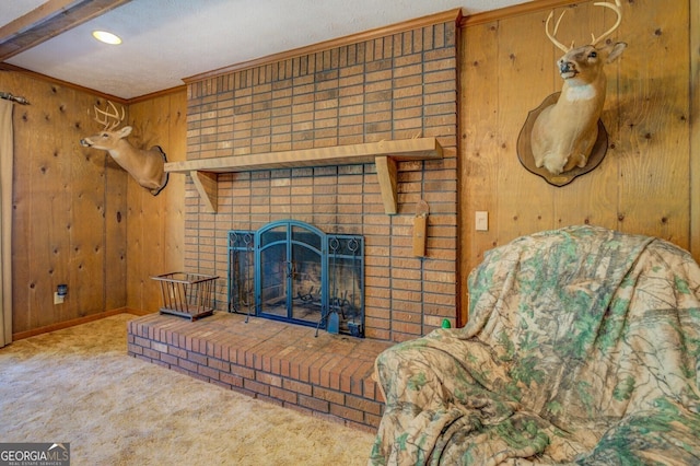 carpeted living room with a textured ceiling, a fireplace, and wood walls