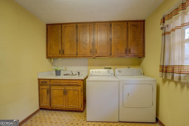 laundry area featuring cabinets, separate washer and dryer, sink, and a textured ceiling