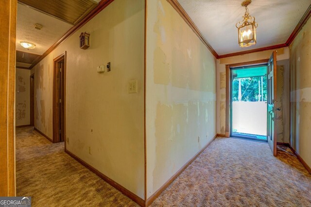 hallway with light colored carpet, ornamental molding, and a notable chandelier