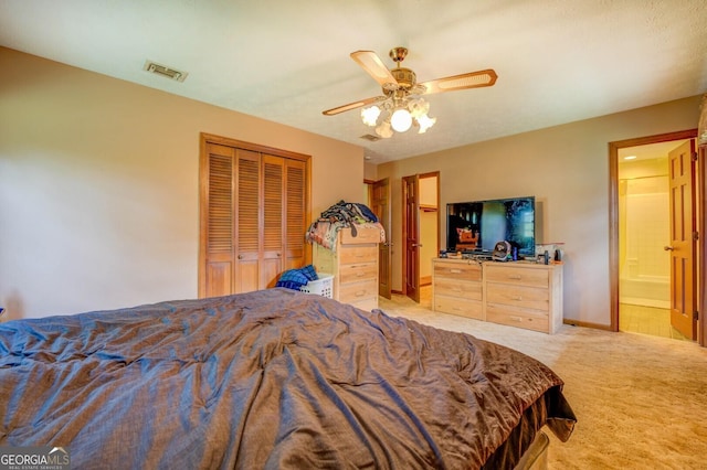 bedroom featuring ensuite bath, light colored carpet, a closet, and ceiling fan