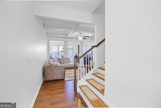 stairs with hardwood / wood-style floors, ornate columns, ceiling fan, beam ceiling, and coffered ceiling