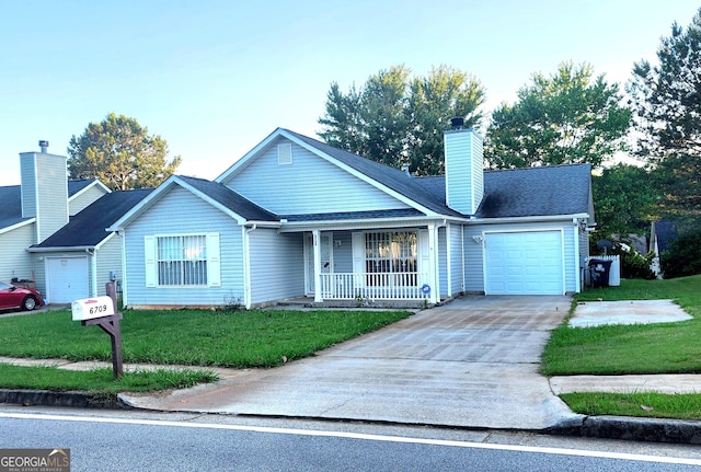 view of front of property featuring a front yard, a garage, and a porch