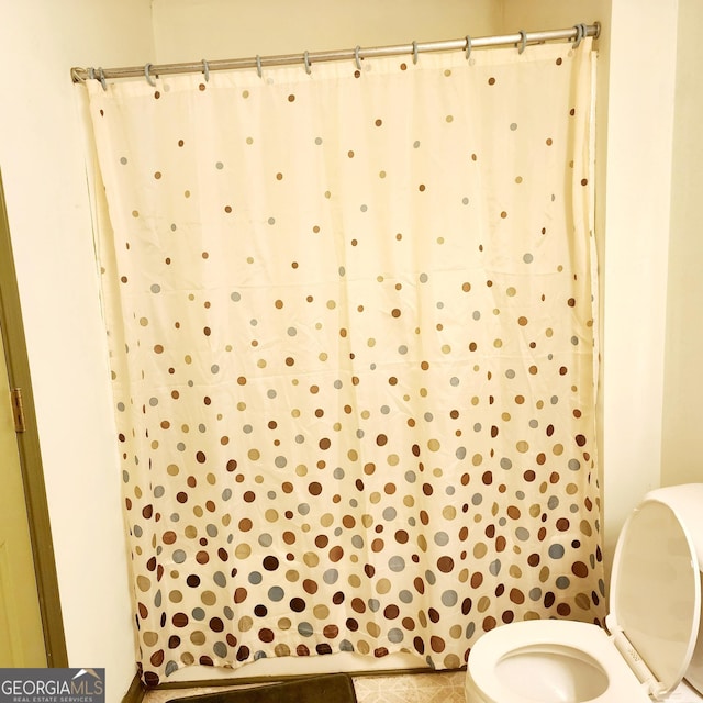 bathroom with toilet and tile patterned flooring