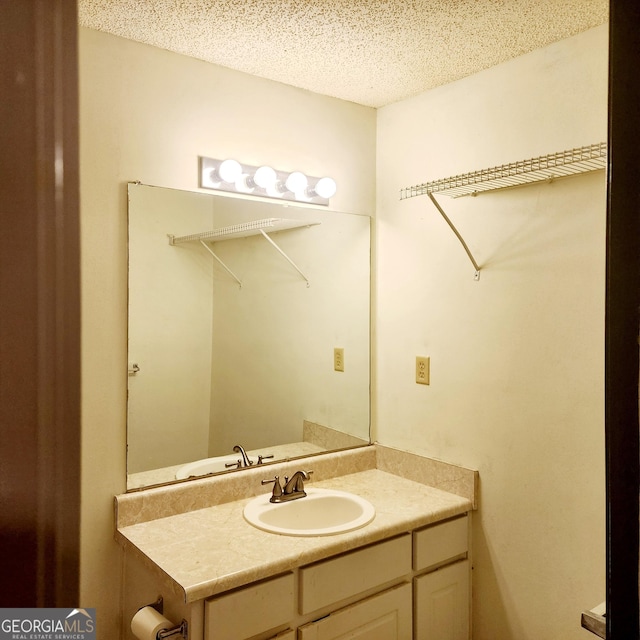 bathroom featuring a textured ceiling and vanity