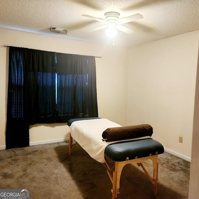 carpeted bedroom featuring ceiling fan and a textured ceiling