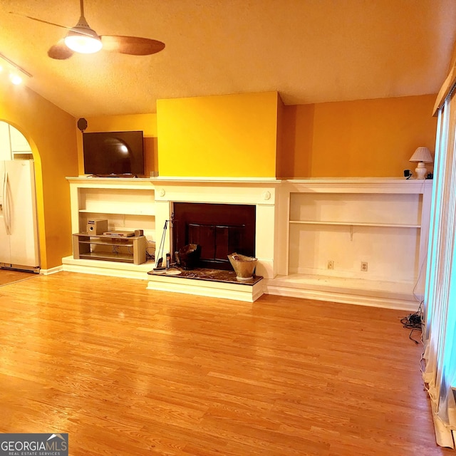 unfurnished living room featuring ceiling fan and hardwood / wood-style flooring