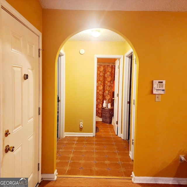 corridor featuring tile patterned floors and a textured ceiling