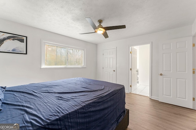 bedroom featuring ceiling fan, a textured ceiling, and wood-type flooring