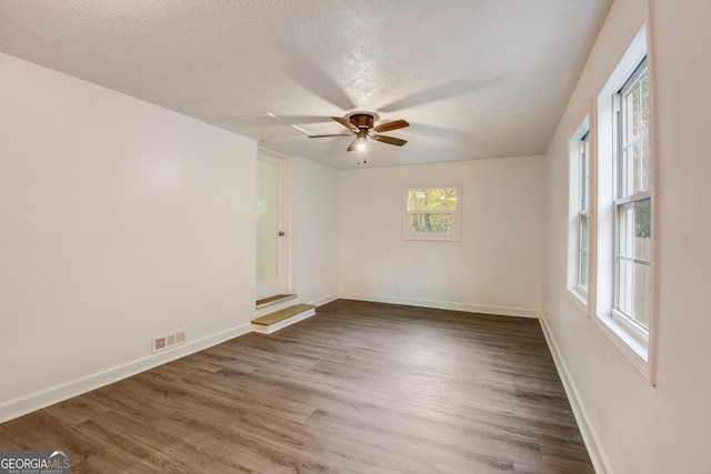 unfurnished room featuring ceiling fan, dark hardwood / wood-style flooring, and a textured ceiling