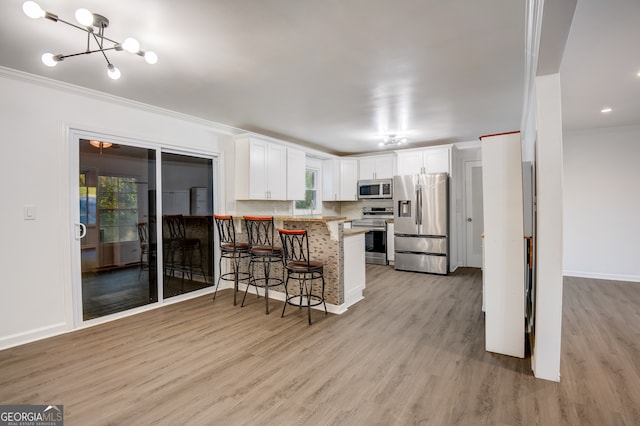 kitchen featuring decorative backsplash, white cabinets, kitchen peninsula, stainless steel appliances, and a breakfast bar area