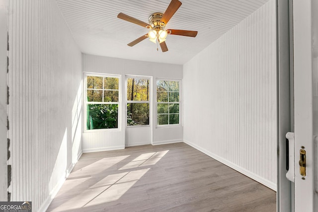 unfurnished sunroom featuring ceiling fan