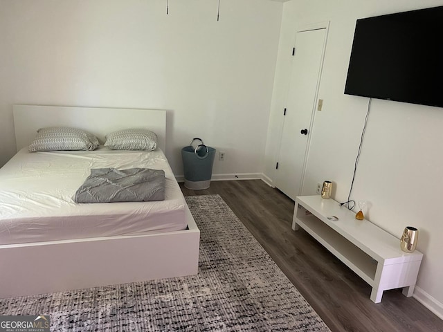 bedroom with dark hardwood / wood-style flooring