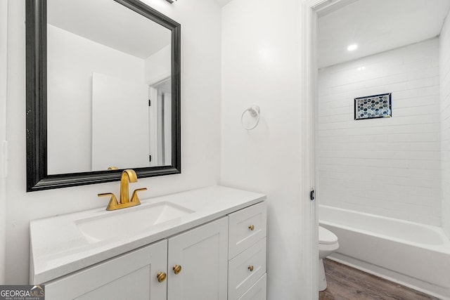 full bathroom featuring hardwood / wood-style flooring, toilet, vanity, and tiled shower / bath combo