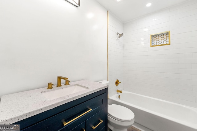 full bathroom with toilet, vanity, and tiled shower / bath