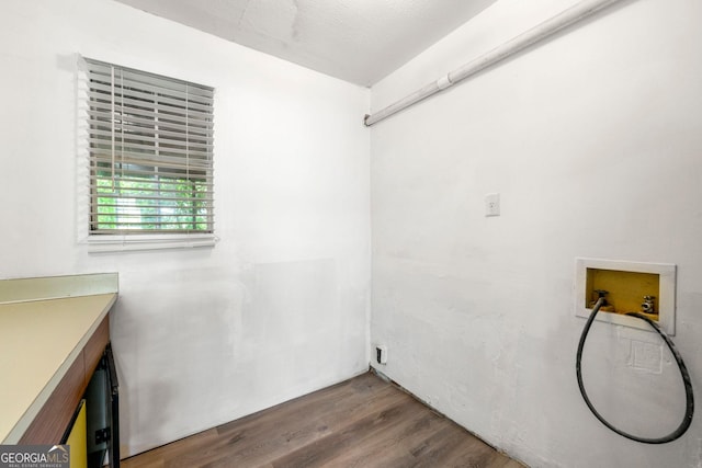 laundry area featuring washer hookup, a textured ceiling, and dark hardwood / wood-style floors