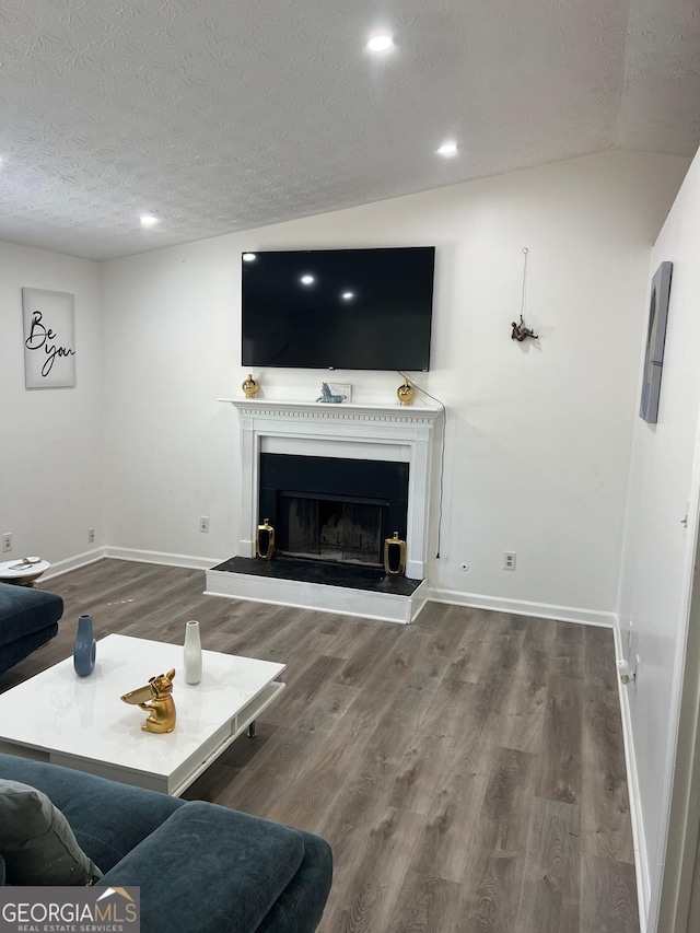 living room featuring a textured ceiling, lofted ceiling, and hardwood / wood-style flooring