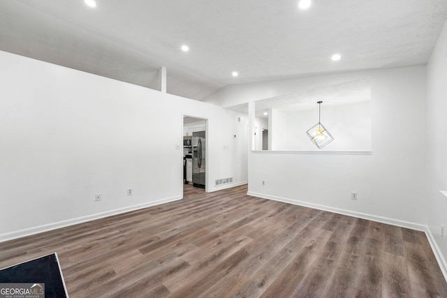 unfurnished living room with vaulted ceiling and wood-type flooring