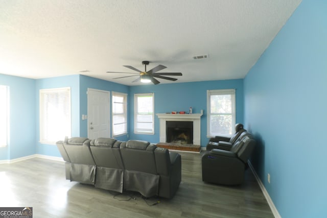 living room featuring ceiling fan, wood-type flooring, and a textured ceiling