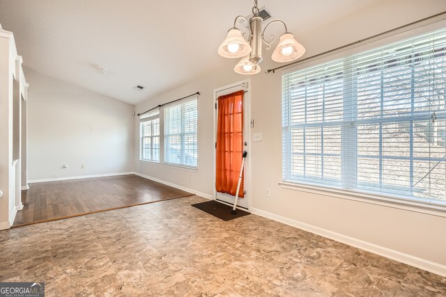 entrance foyer with a healthy amount of sunlight, hardwood / wood-style flooring, and a notable chandelier