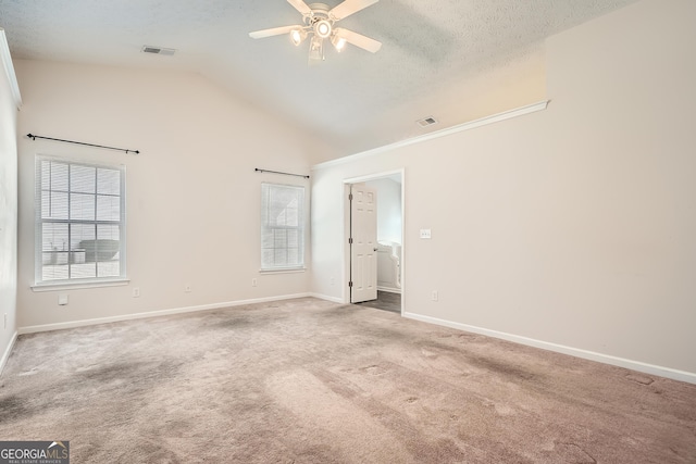 unfurnished bedroom featuring baseboards, visible vents, vaulted ceiling, a textured ceiling, and carpet flooring