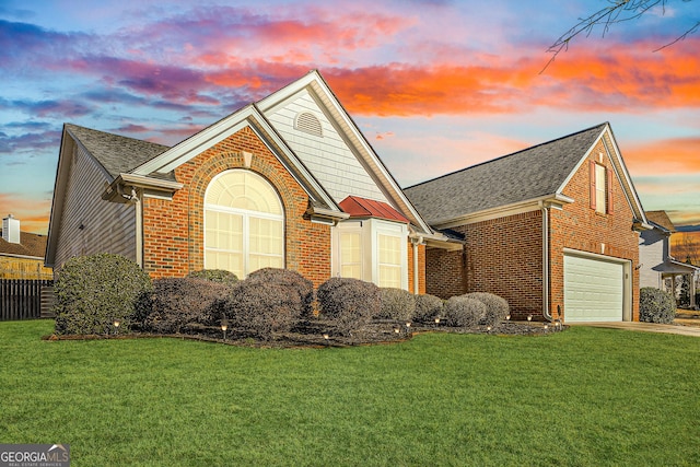 view of front of home with an attached garage, brick siding, a shingled roof, driveway, and a lawn