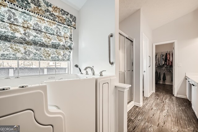 bathroom featuring separate shower and tub, vanity, wood-type flooring, and a textured ceiling