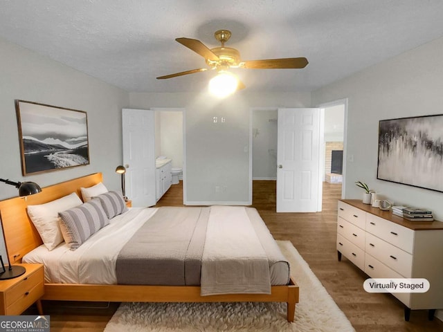 bedroom featuring a textured ceiling, ceiling fan, ensuite bathroom, and dark hardwood / wood-style flooring