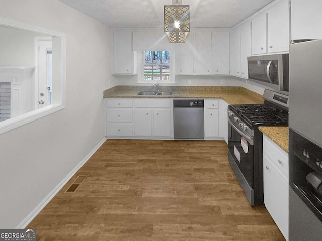 kitchen with dark hardwood / wood-style floors, stainless steel appliances, white cabinetry, and sink