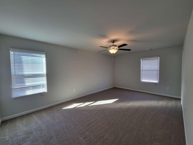 empty room featuring dark colored carpet and ceiling fan