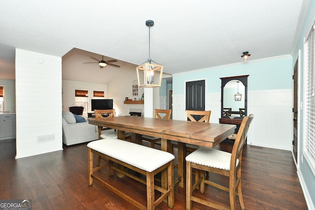 dining space featuring ceiling fan, dark hardwood / wood-style floors, crown molding, and lofted ceiling