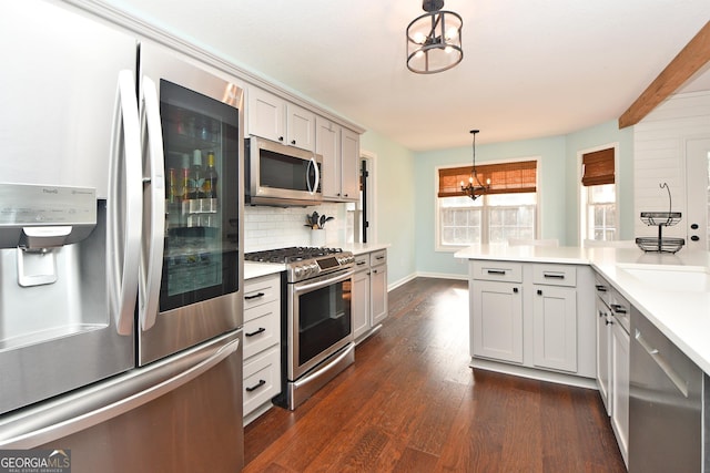 kitchen featuring stainless steel appliances, backsplash, hanging light fixtures, a chandelier, and beamed ceiling