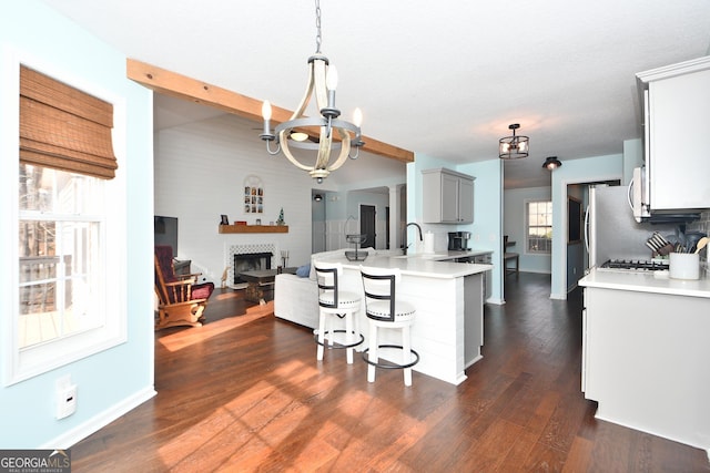 kitchen with decorative light fixtures, a kitchen bar, dark hardwood / wood-style flooring, sink, and gray cabinets