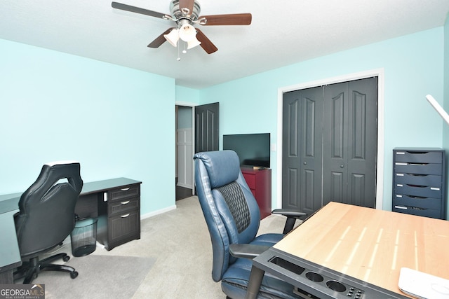 carpeted home office featuring ceiling fan