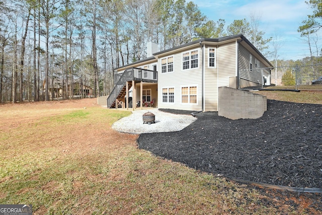 exterior space with a deck, an outdoor fire pit, and a front yard