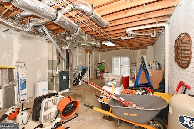 basement featuring brick wall and heating unit