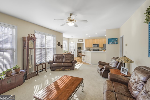 carpeted living room featuring ceiling fan