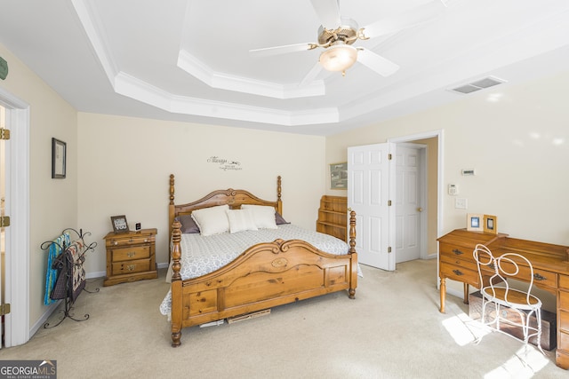 bedroom featuring a tray ceiling, ornamental molding, light colored carpet, and ceiling fan