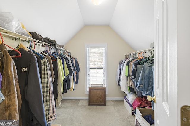 walk in closet featuring lofted ceiling and light colored carpet