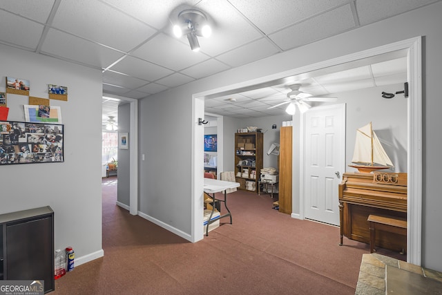 corridor with a drop ceiling and dark carpet