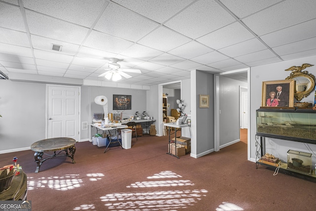 interior space featuring ceiling fan, a paneled ceiling, and dark carpet