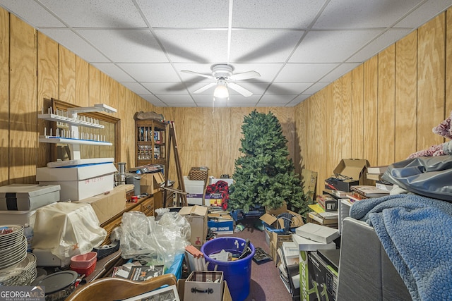 miscellaneous room with ceiling fan and wood walls