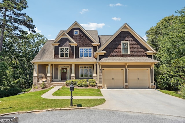 craftsman house with a garage, a front yard, and covered porch