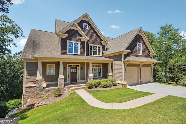 craftsman house with a front lawn, covered porch, and a garage