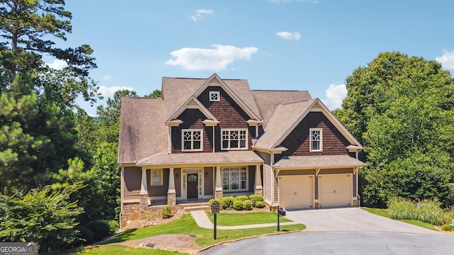 craftsman-style home with a front yard, covered porch, and a garage