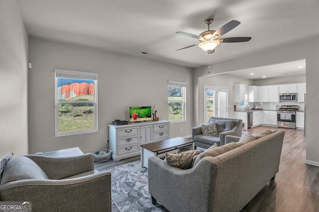 living room with hardwood / wood-style flooring and ceiling fan