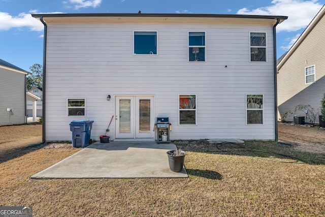 back of house with central AC unit, a lawn, and a patio area