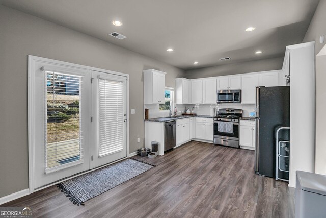 kitchen featuring appliances with stainless steel finishes, dark hardwood / wood-style flooring, sink, and white cabinets