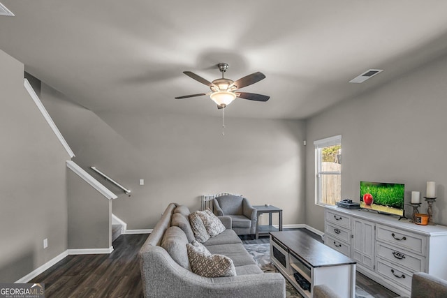 living room featuring dark wood-type flooring and ceiling fan