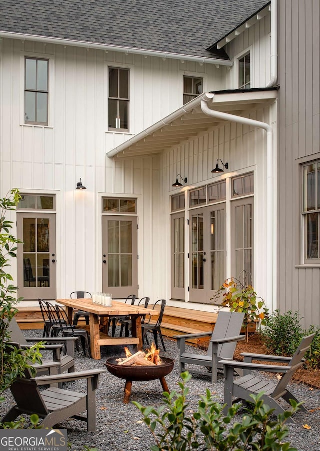 back of house featuring an outdoor fire pit, french doors, and roof with shingles